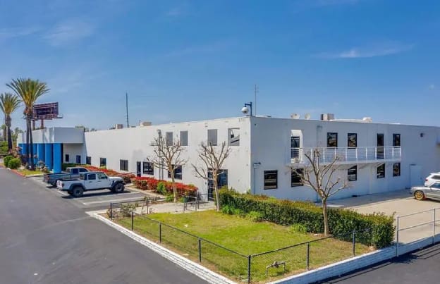 A white building with trees in front of it