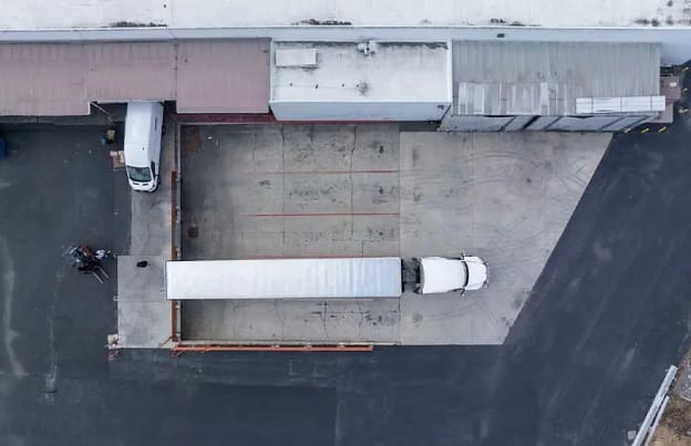 A truck parked in the middle of a parking lot.